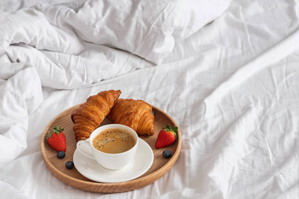 Caffè e croissant sulle lenzuola bianche primo piano
 - Foto, immagini