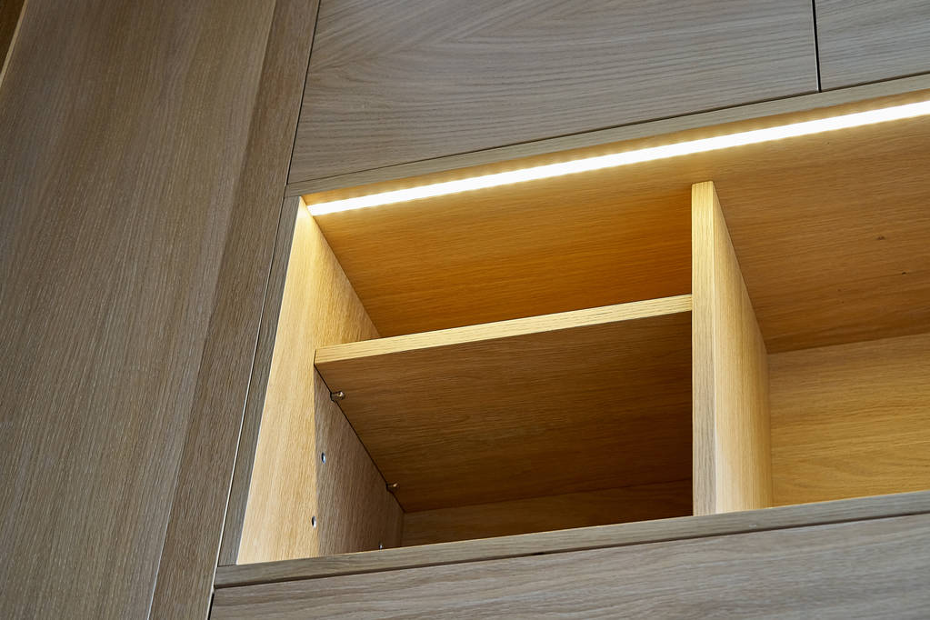 Armoire en bois avec tiroirs, étagères vides et lumières LED. Mobilier moderne
 - Photo, image