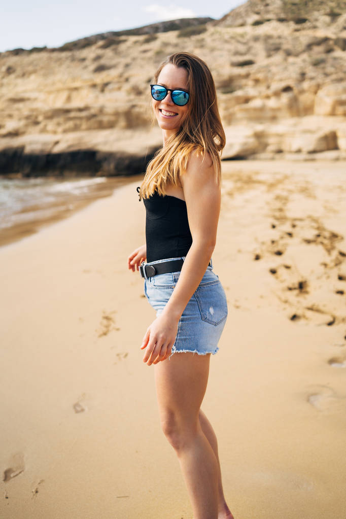 夏休みにビーチを歩くかなり若い女性 - 写真・画像