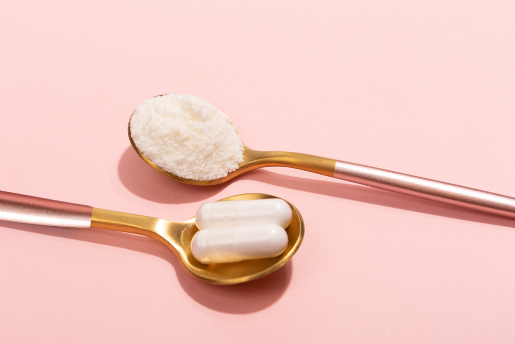 Collagen powder and pills on pink background - Photo, Image