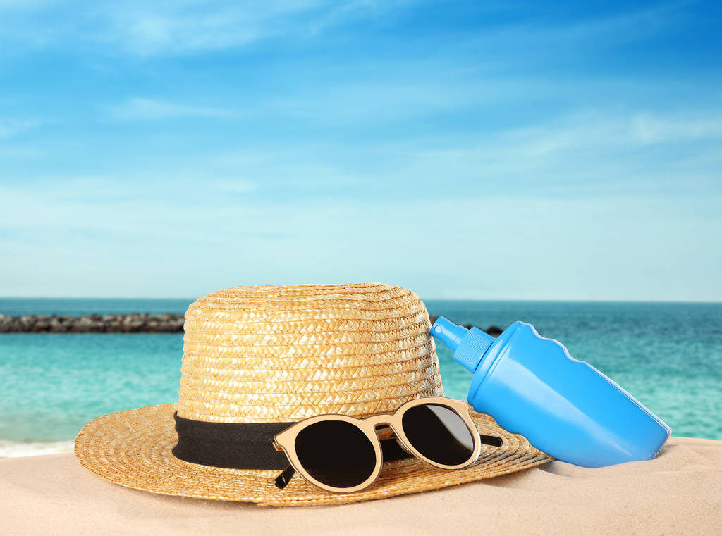 Bottiglia di crema solare per il corpo e accessori da spiaggia sulla sabbia. Spazio per il design
  - Foto, immagini