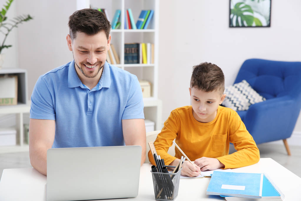 Dad helping his son with homework in room - Photo, Image