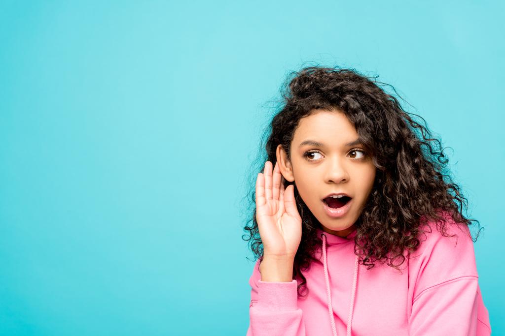 shocked curly african american girl touching ear isolated on blue  - Photo, Image