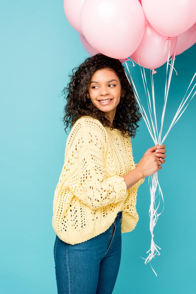 hermosa afroamericana chica sosteniendo rosa globos de aire aislado en azul
 - Foto, imagen