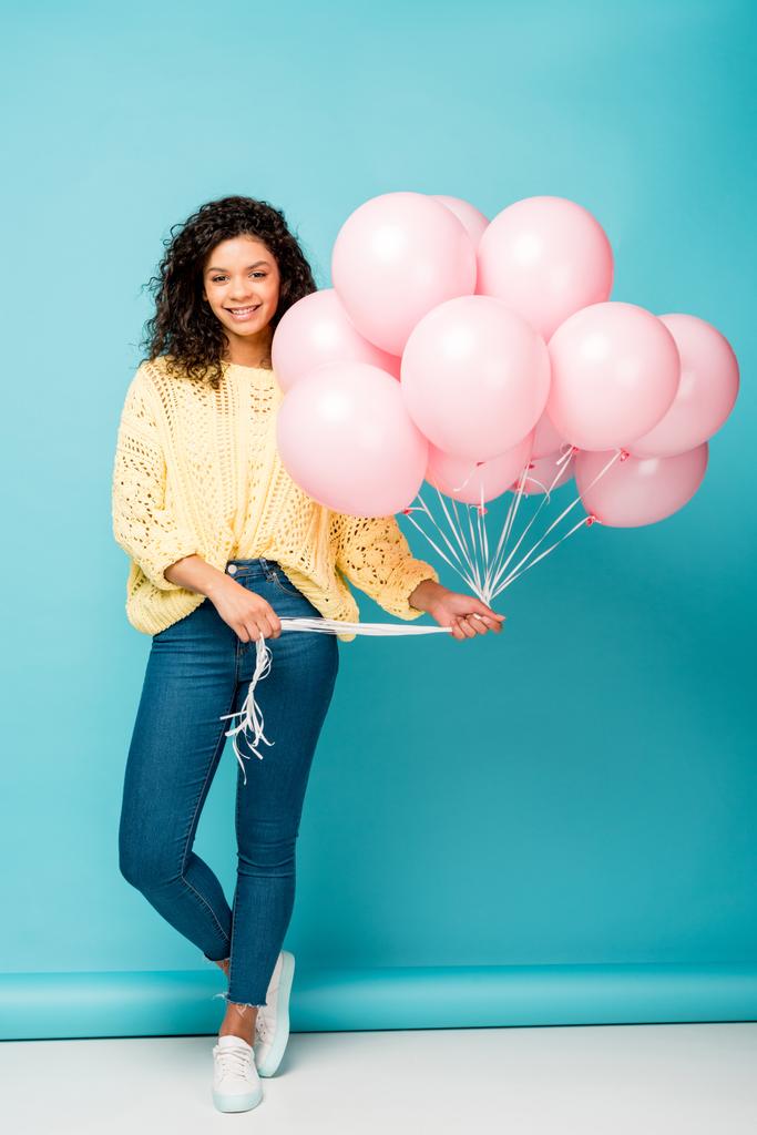 ブルーにピンクのエア風船を持っている魅力的なアフリカ系アメリカ人の女の子 - 写真・画像