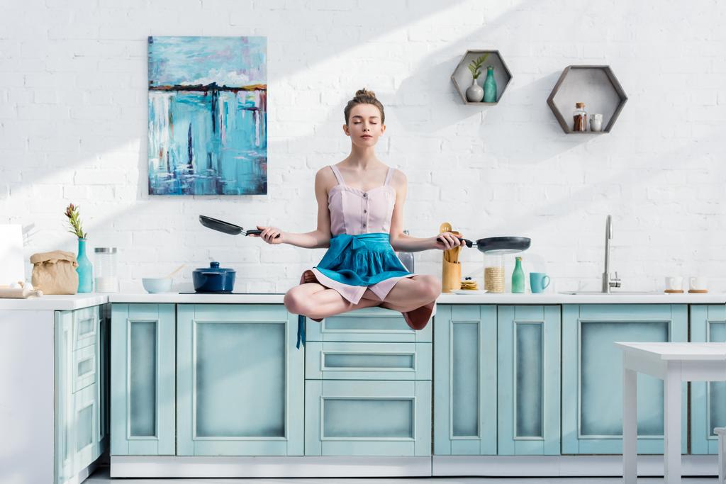 若い女性の手で鍋でロータス ポーズ内の空気で瞑想 - 写真・画像