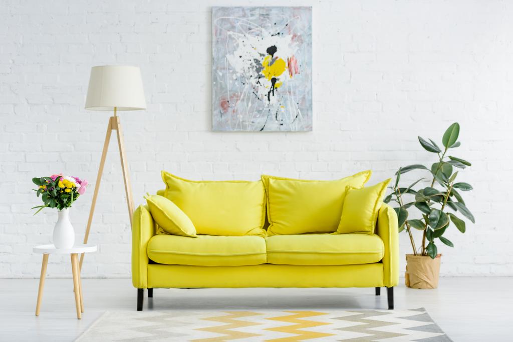 інтер'єр сучасної білої вітальні з декором і яскраво-жовтим диваном
 - Фото, зображення