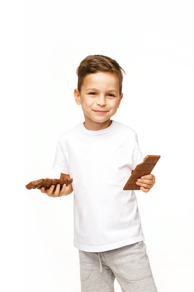 piccolo bel ragazzo in possesso di cioccolatini studio girato
  - Foto, immagini
