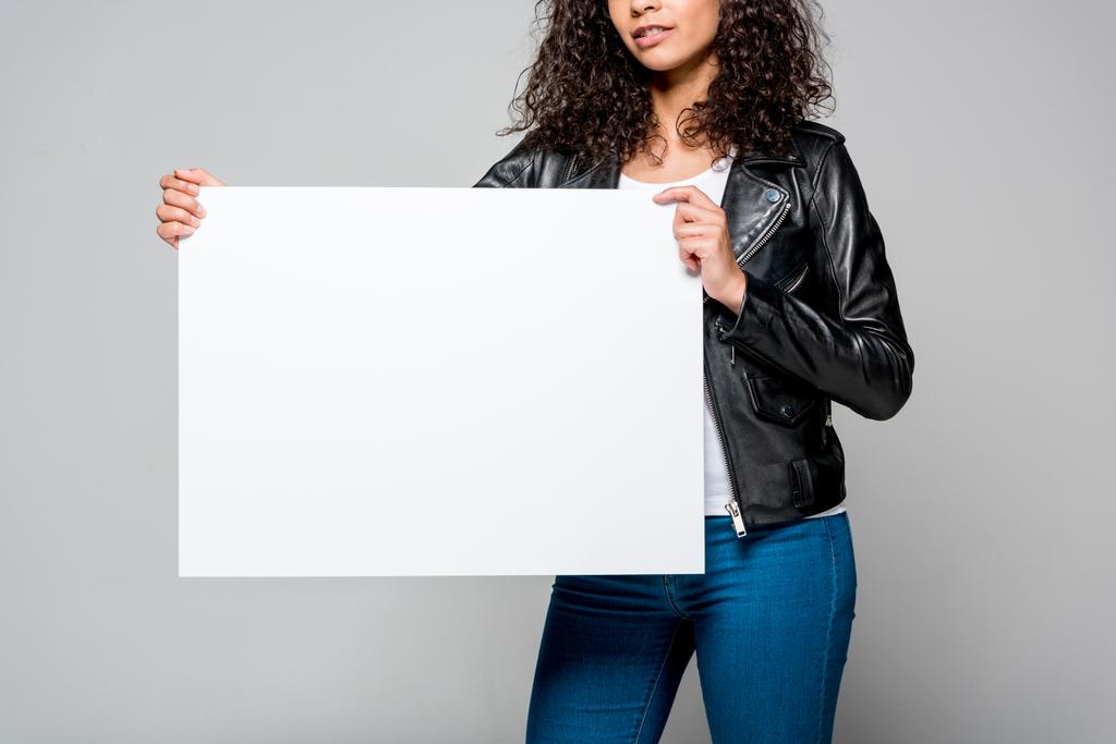vue recadrée d'une jeune femme afro-américaine tenant une pancarte blanche isolée sur du gris
 - Photo, image