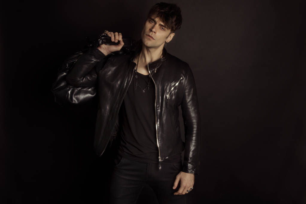 Strong stripped muscle male model in casual look in black leather jacket on black isolated font background - Photo, Image