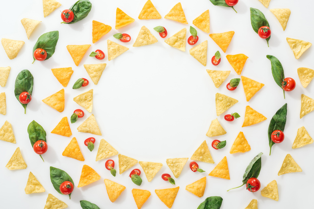 pohled na chutné nachos a nakrájené papriky s bazalkou a třešňovkami na bílém pozadí  - Fotografie, Obrázek