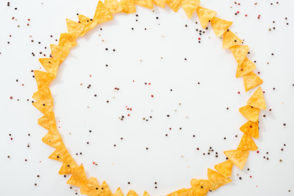 bovenaanzicht van smakelijke nachos en specerijen op witte achtergrond met kopieerruimte  - Foto, afbeelding
