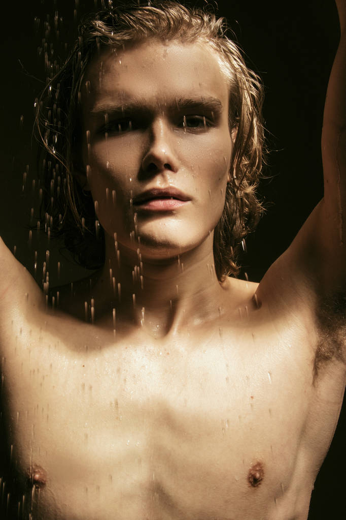 マッスルブロンド美しいです裸の男性モデルとともに長いです毛の肖像画で水滴上のベージュブラウン隔離されたフォントの背景 - 写真・画像