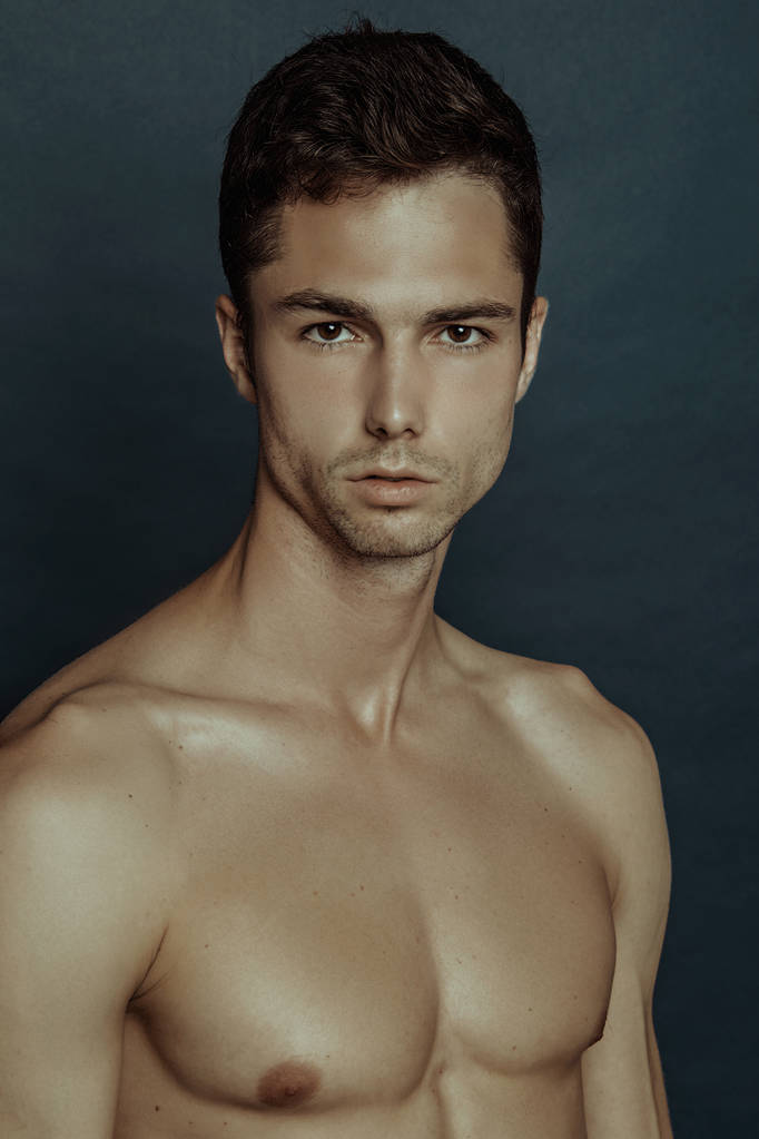 Forte modelo masculino músculo despojado com toalha branca em azul isolado fonte de fundo
 - Foto, Imagem