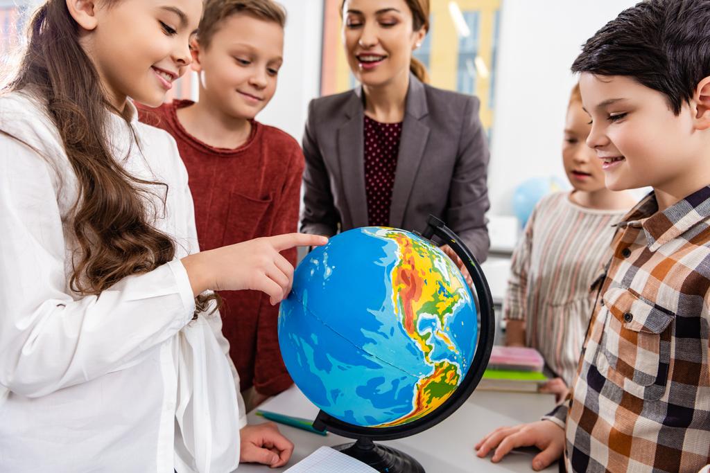 Enseignant et élèves regardant le globe tout en étudiant la géographie en classe
 - Photo, image