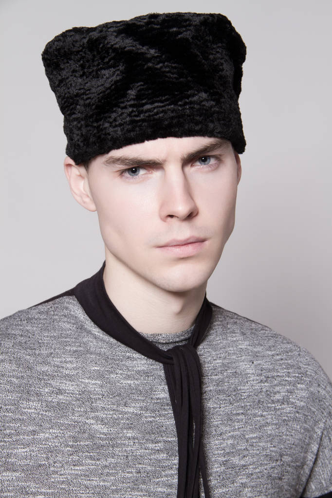 schöne starke Gesicht männliche Modell in Mode Kleider und Hut auf weißen isolierten Schrift Hintergrund - Foto, Bild