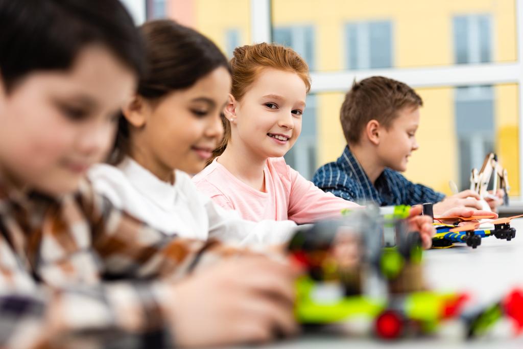 Žáci, kteří sedí u stolu s hračkami během lekce ve třídě - Fotografie, Obrázek