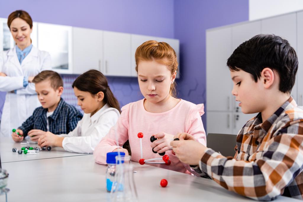Tiivistetyt oppilaat, joilla on molekyylirakenteet, kun he istuvat luokkahuoneessa kemian tunnin aikana
 - Valokuva, kuva