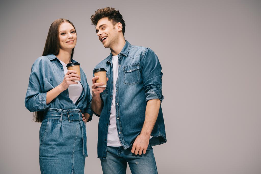 girlfriend in denim dress and smiling boyfriend in jeans and shirt holding paper cups  - Photo, Image