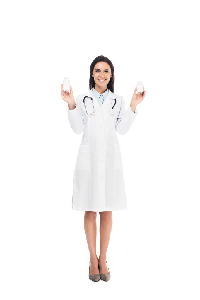 Teljes hossza nézet orvos sztetoszkóp gazdaság tabletták elszigetelt fehér fehér kabát - Fotó, kép