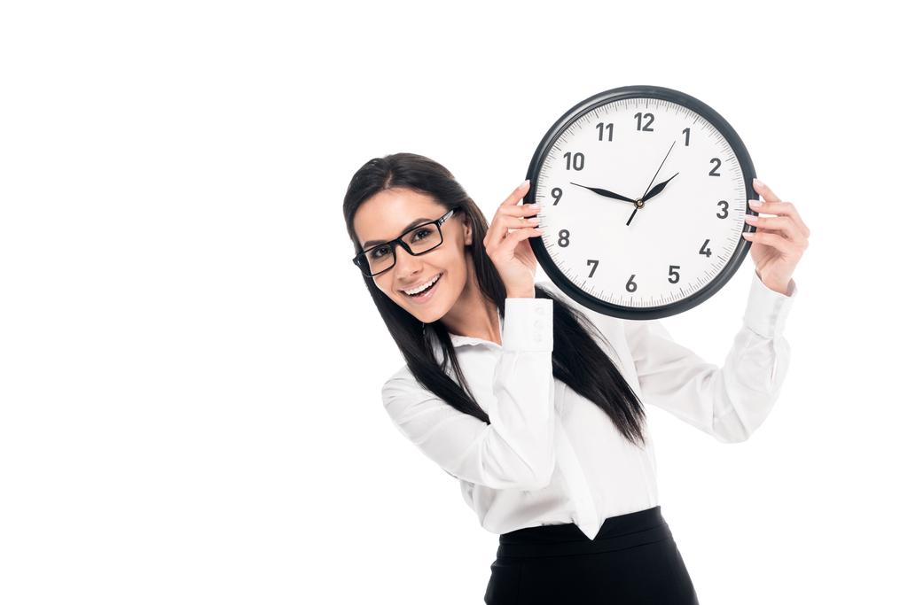 Smiling brunette businesswoman in shirt holding clock isolated on white - Photo, Image