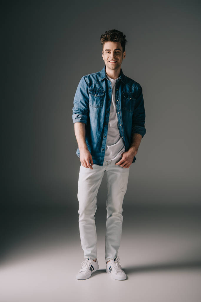 smiling handsome man in denim shirt and jeans looking at camera  - Photo, Image