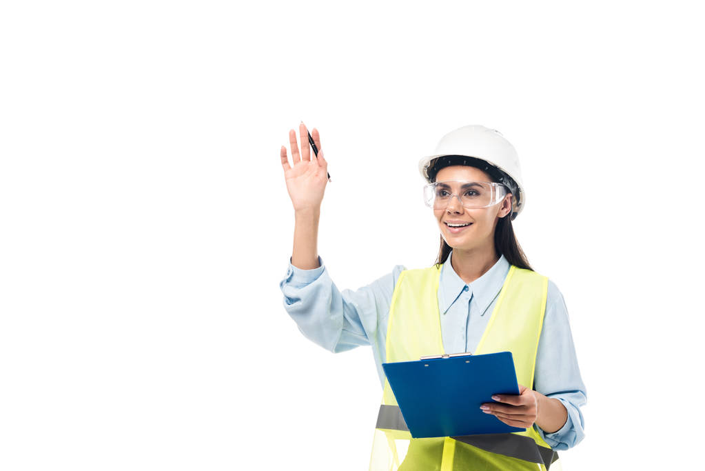 Ingenieur in festem Hut mit Klemmbrett und winkender Hand isoliert auf weiß - Foto, Bild