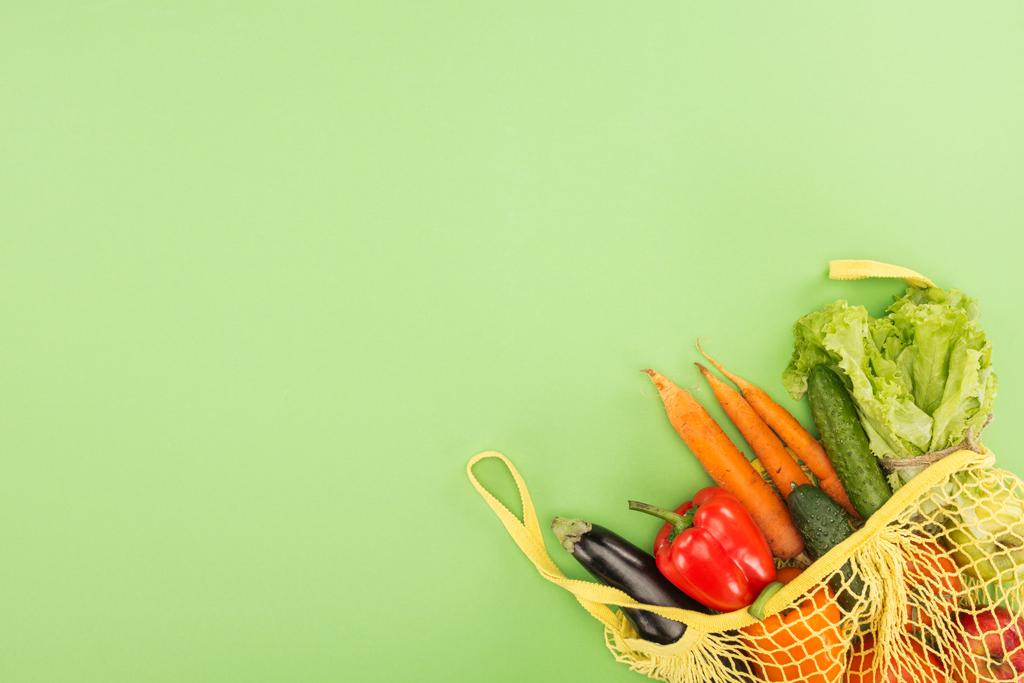 pimentão vermelho, cenouras, alface, pepinos e berinjela em saco de corda amarela no fundo verde claro
 - Foto, Imagem