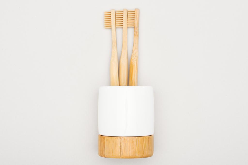 natural bamboo toothbrushes in stand on grey background - Photo, Image