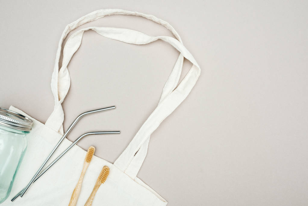 puiset hammasharjat, uudelleenkäytettävät ruostumattomasta teräksestä valmistetut pillit ja lasipurkki valkoisessa puuvillapussissa
 - Valokuva, kuva