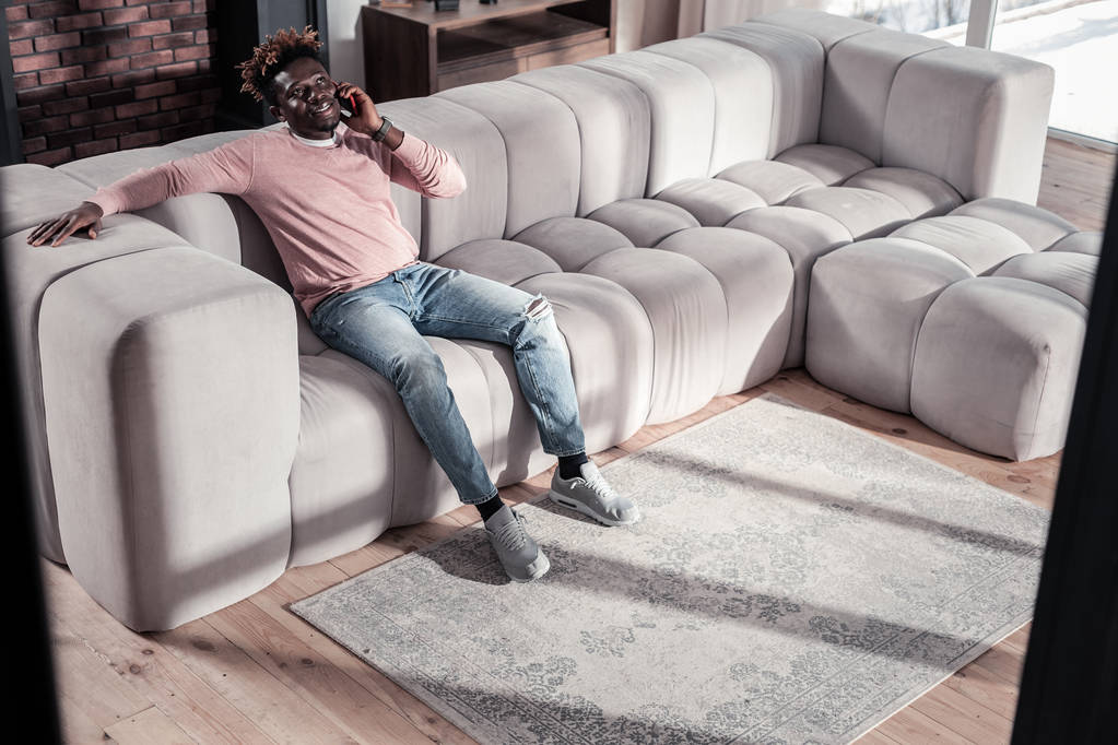 Relajado hombre internacional sentado en el sofá
 - Foto, Imagen
