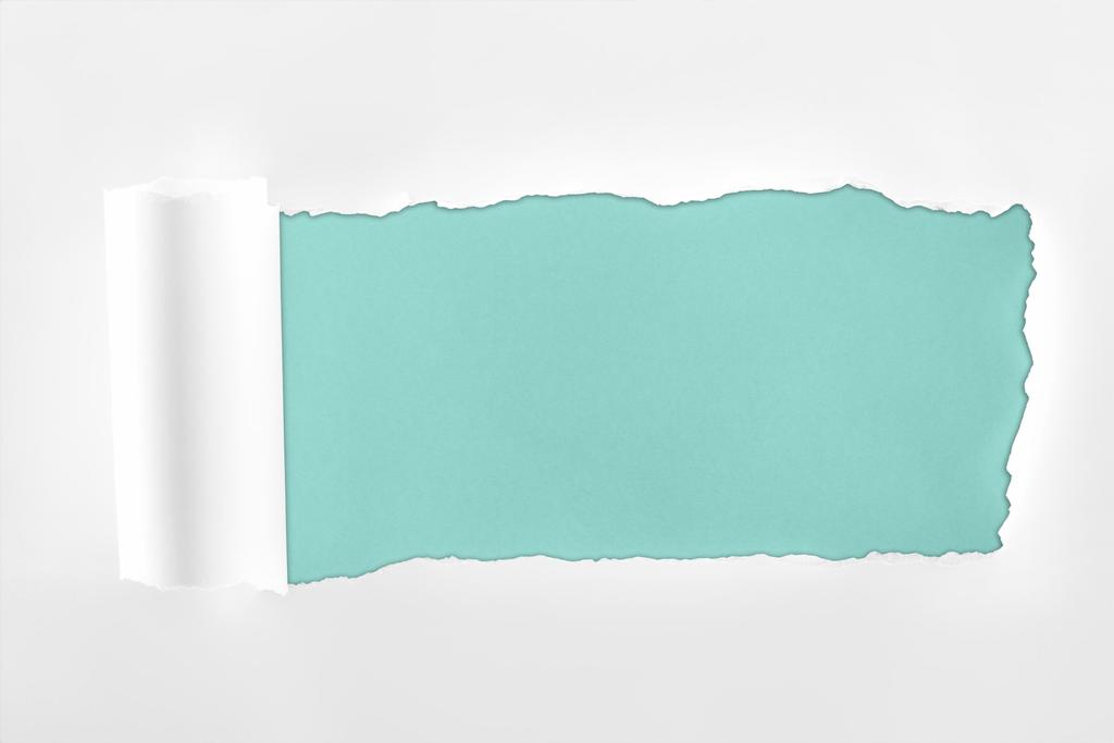 明るい青色の背景に圧延エッジを持つ不規則なテクスチャの白い紙  - 写真・画像