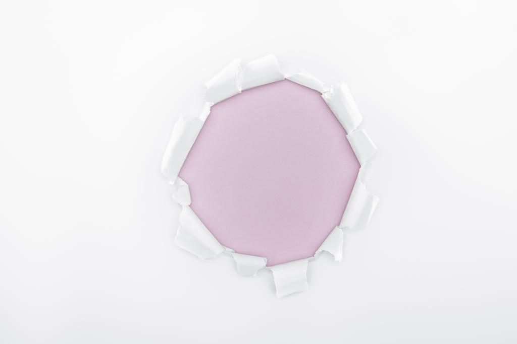 ragged hole in textured white paper on light purple background  - Photo, Image