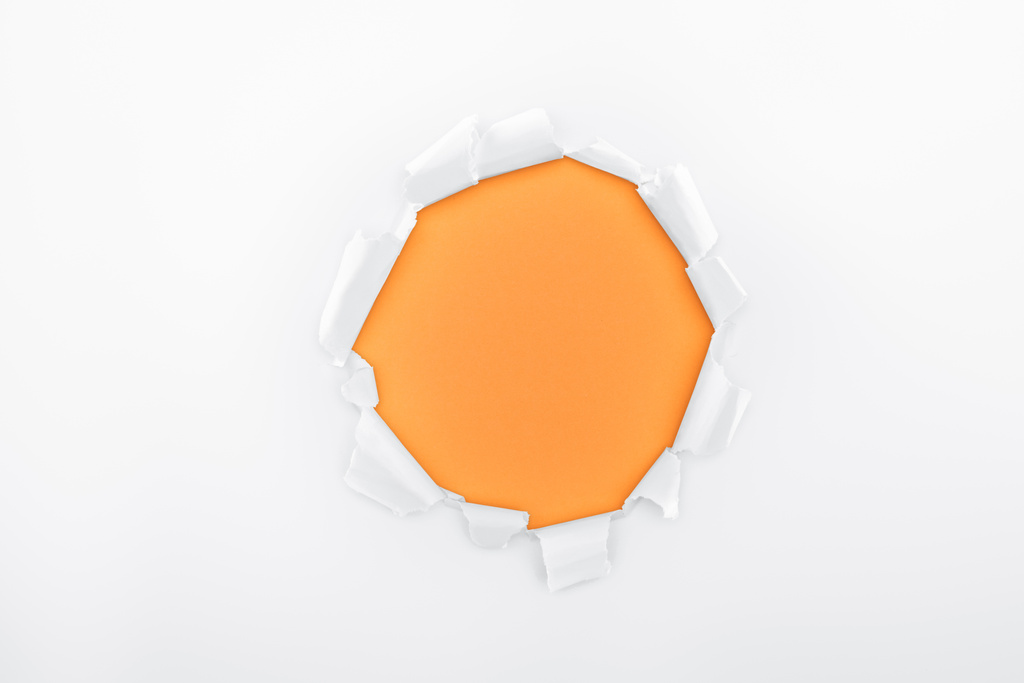 agujero rasgado en papel blanco texturizado sobre fondo naranja
  - Foto, imagen