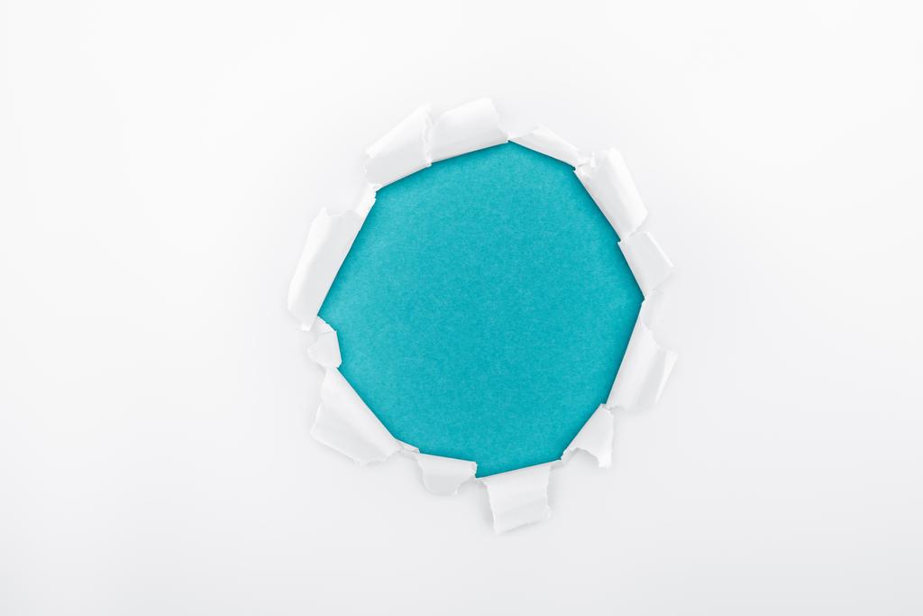 buraco irregular em papel branco texturizado sobre fundo azul
  - Foto, Imagem