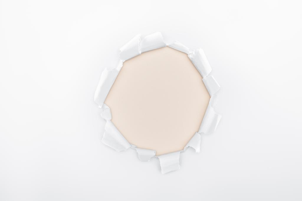 agujero rasgado en papel blanco texturizado sobre fondo marfil
  - Foto, Imagen