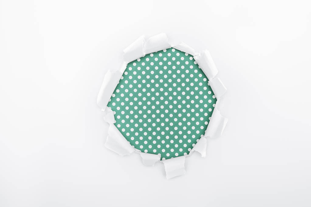 σχισμένη τρύπα σε λευκό χαρτί με υφή σε πράσινο διακεκομμένο φόντο  - Φωτογραφία, εικόνα