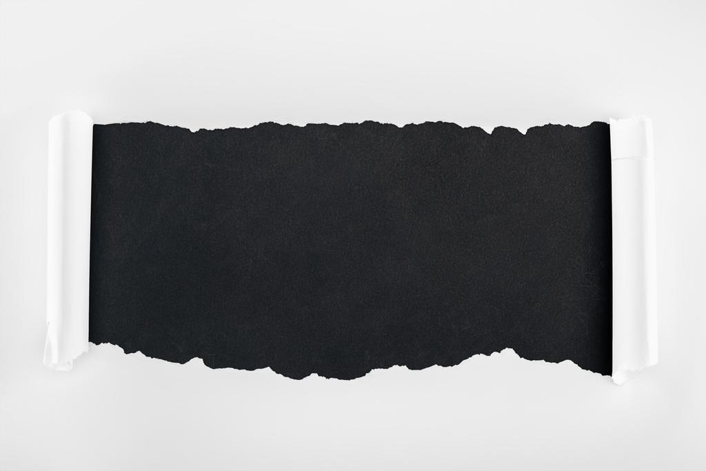 bílý papír s potrhanou texturou s okraji kudrlinkou na černém pozadí  - Fotografie, Obrázek