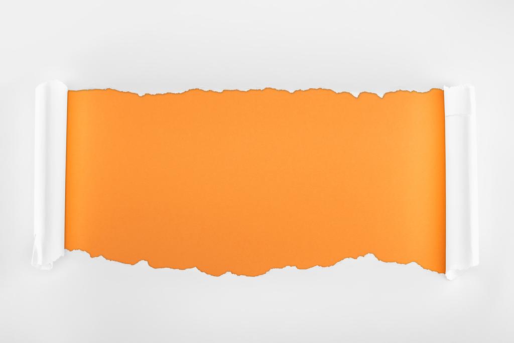 λευκό χαρτί με ακανόνιστη υφή με καμπυλωση άκρων σε πορτοκαλί φόντο  - Φωτογραφία, εικόνα