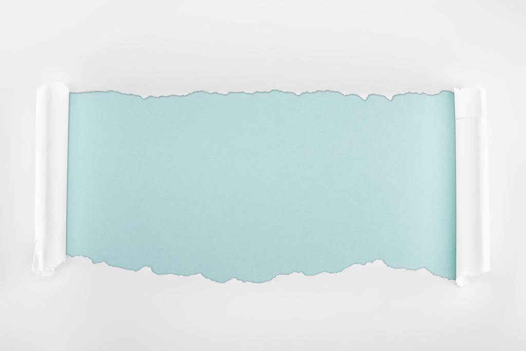 κουρελιασμένο λευκό χαρτί με υφή με καμπυλωση άκρων σε ανοιχτό μπλε φόντο  - Φωτογραφία, εικόνα