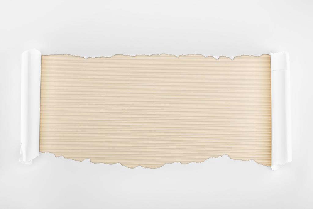 roztrhaný bílý texturované papír s okraji kudrlinkou na pozadí proužkované slonovinou  - Fotografie, Obrázek