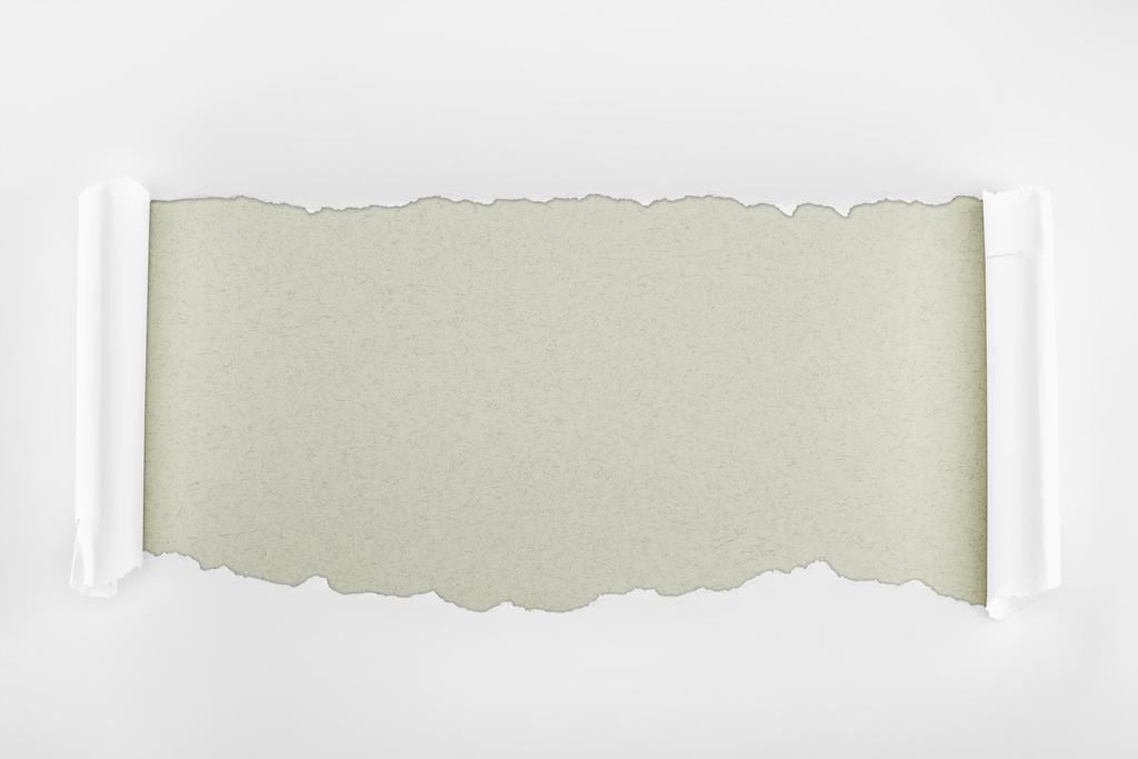 zerrissenes weißes strukturiertes Papier mit Lockenrändern auf grauem Hintergrund  - Foto, Bild