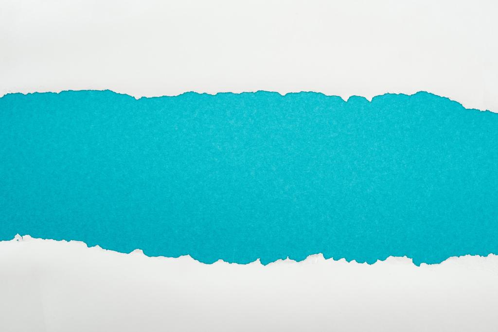 λευκό χαρτί με ακανόνιστη επιφάνεια με χώρο αντιγραφής σε μπλε φόντο  - Φωτογραφία, εικόνα