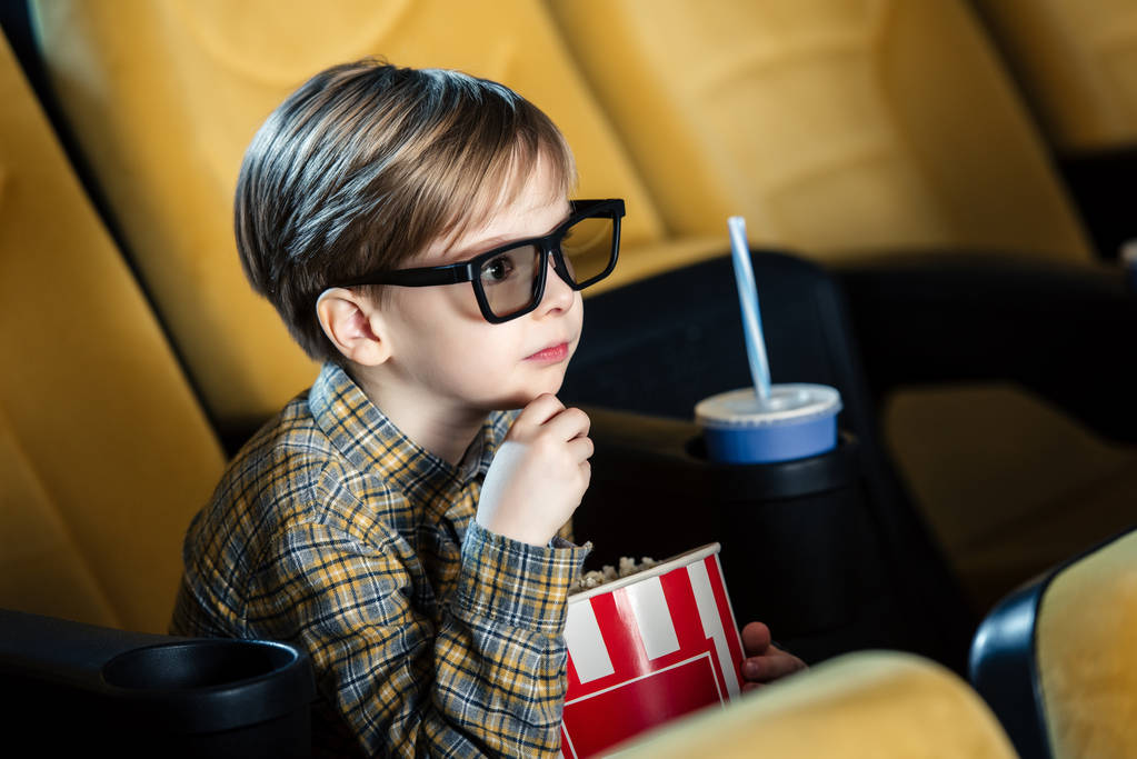 schattige jongen in 3d bril holding papier beker met popcorn - Foto, afbeelding