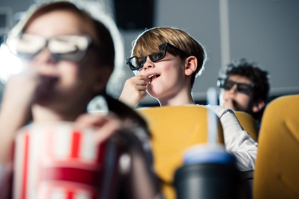 foyer sélectif de l'enfant multiculturel manger du pop-corn et regarder des films au cinéma
 - Photo, image