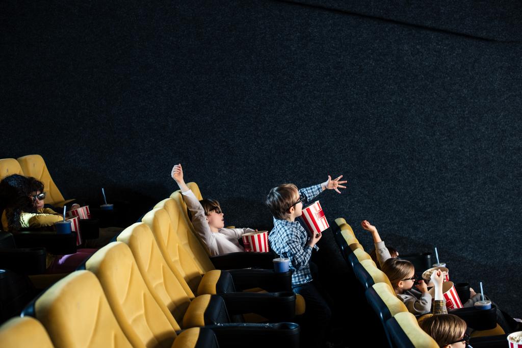 multiculturele vrienden kijken naar film en popcorn eten in de bioscoop  - Foto, afbeelding