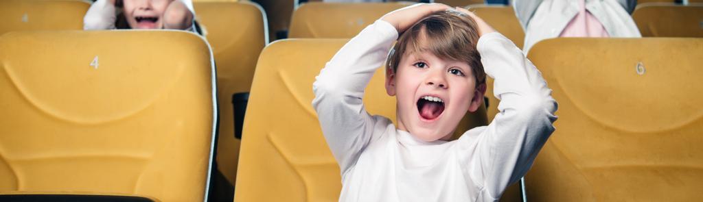 панорамний знімок збудженого хлопчика кричить під час перегляду фільму в кіно
 - Фото, зображення