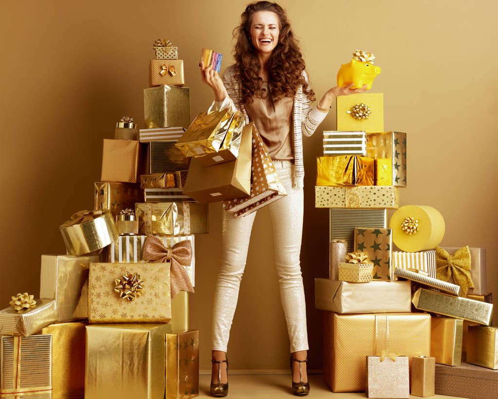 mujer con bolsas de compras, tarjetas de crédito y cerdito amarillo ingenio
 - Foto, imagen
