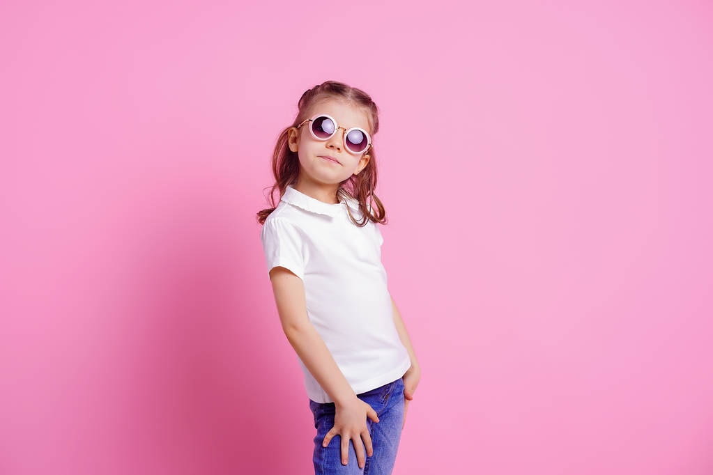 Casual 7 y.o. hembra en gafas de sol redondas rosadas aisladas sobre fondo rosa
 - Foto, imagen