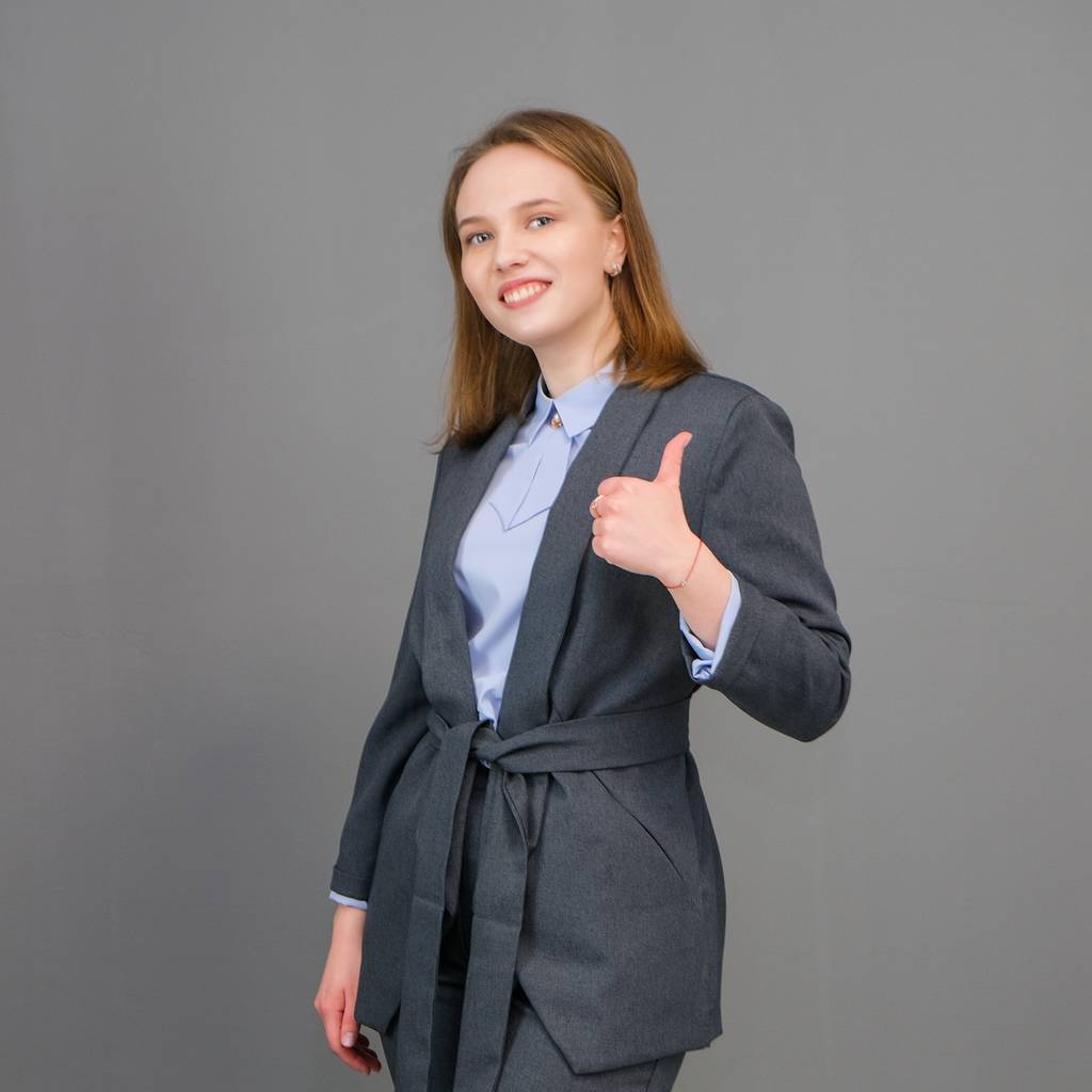 Ritratto di una bella giovane donna d'affari in piedi su sfondo grigio. Una giovane ragazza felice che ride con un trucco naturale e un bel sorriso
. - Foto, immagini